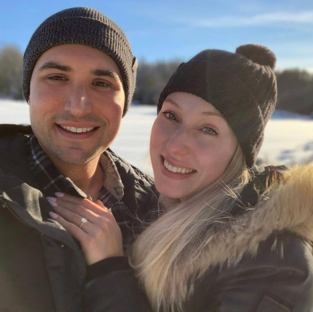 Couple standing together at sunset, the woman’s custom engagement ring catching the light